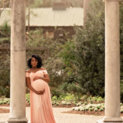 expecting mother standing in garden balancing work and mommyhood